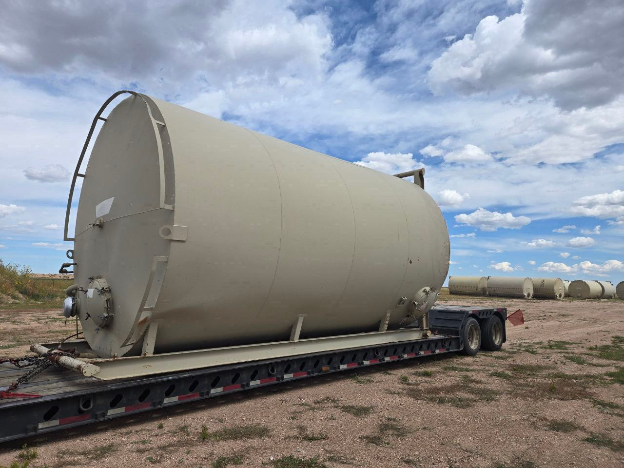 Upright frac tank being transported on truck bed