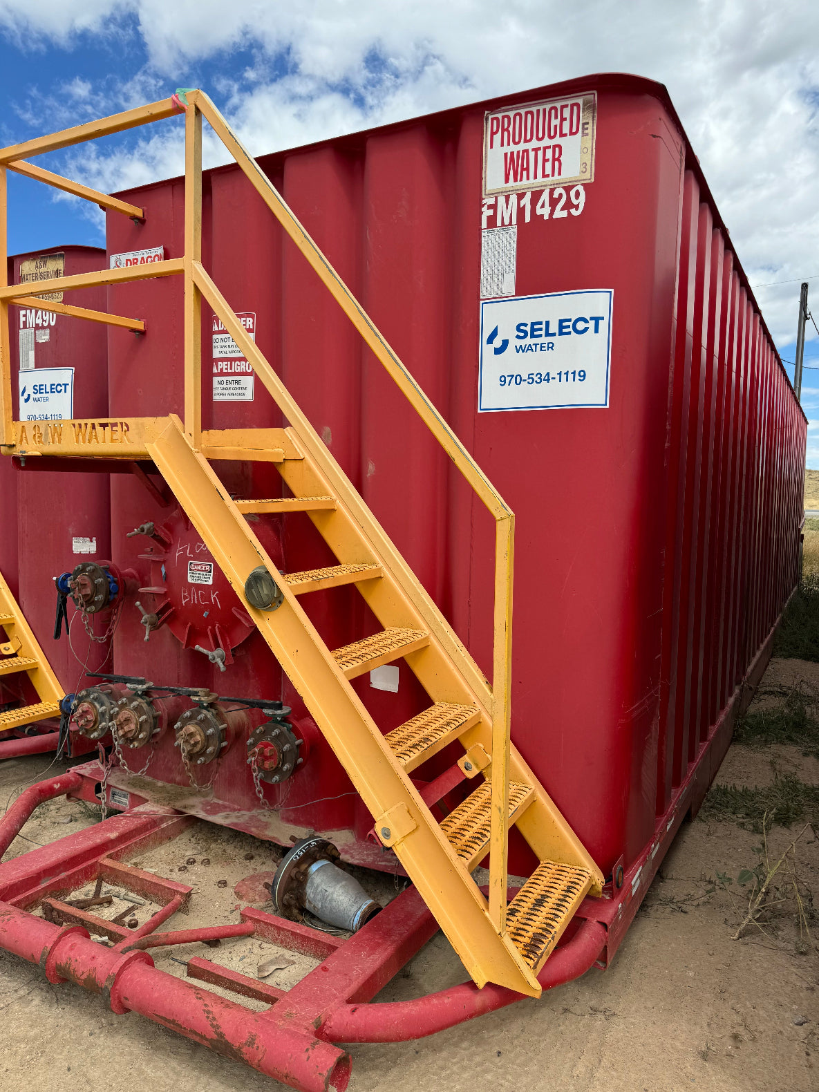 Front facing view of red frac tank with yellow safety ladder
