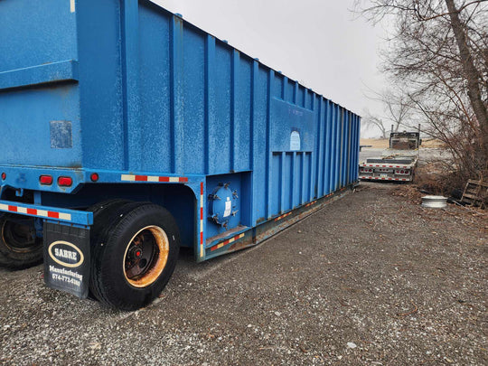 View of the left side of the blue Sabre 21,000 gallon open top weir frac tank #41-0441